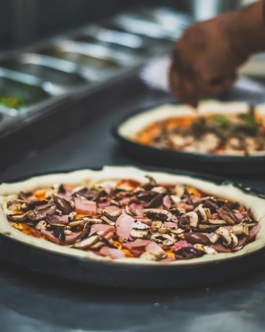Pizza being prepared in the kitchen