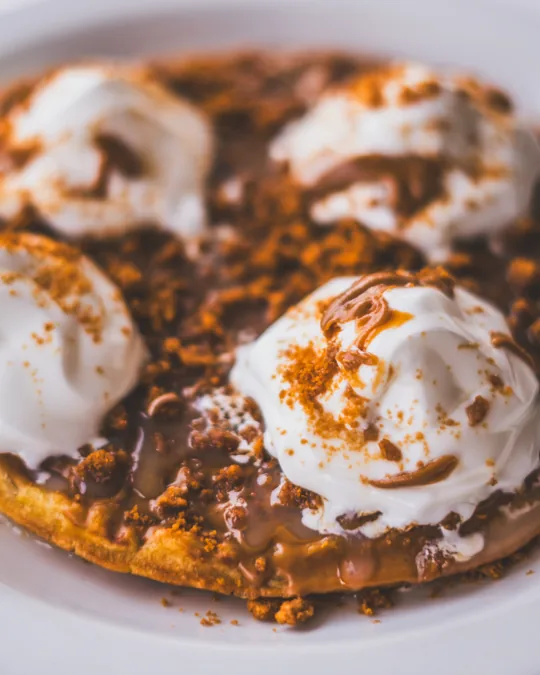 Dessert topped with ice cream and sauce