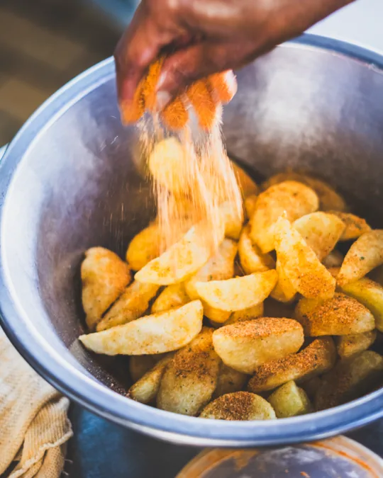 Chips being seasoned in a bowl
