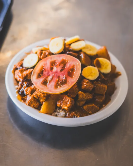 A bowl of chips topped with meat and salad